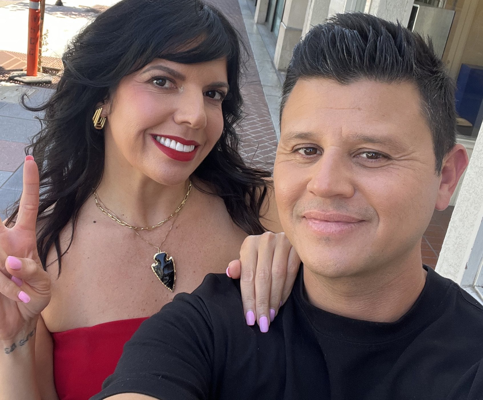 Victor Macias holding a bag of Santana Snacks on the Es Posible set with Fernanda Kelly